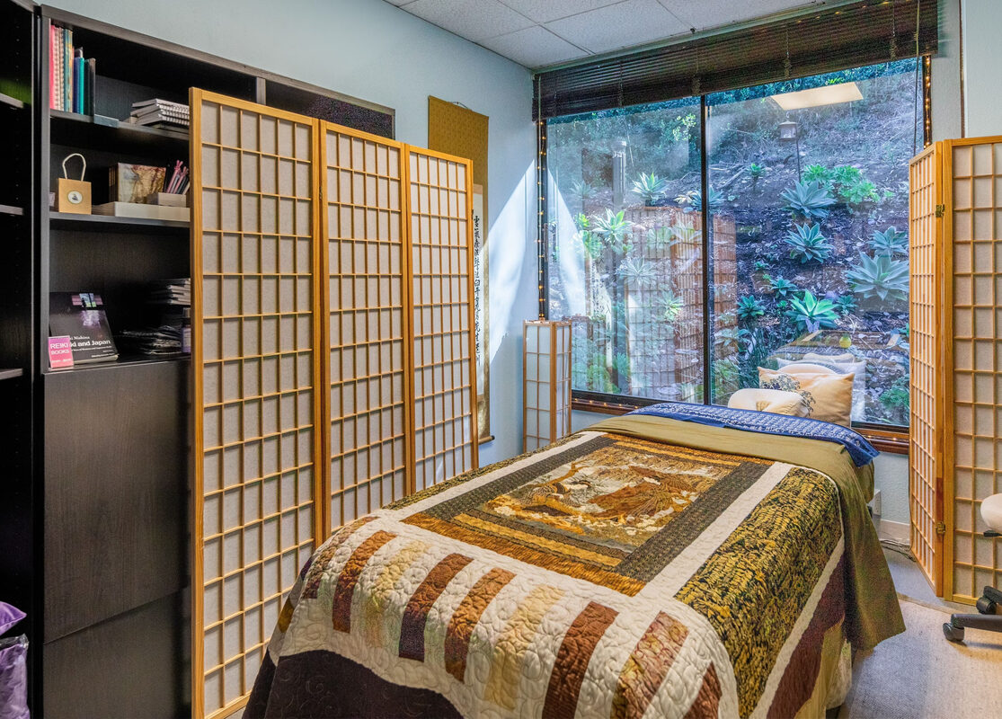 Esthetician suite with blue walls and treatment bed