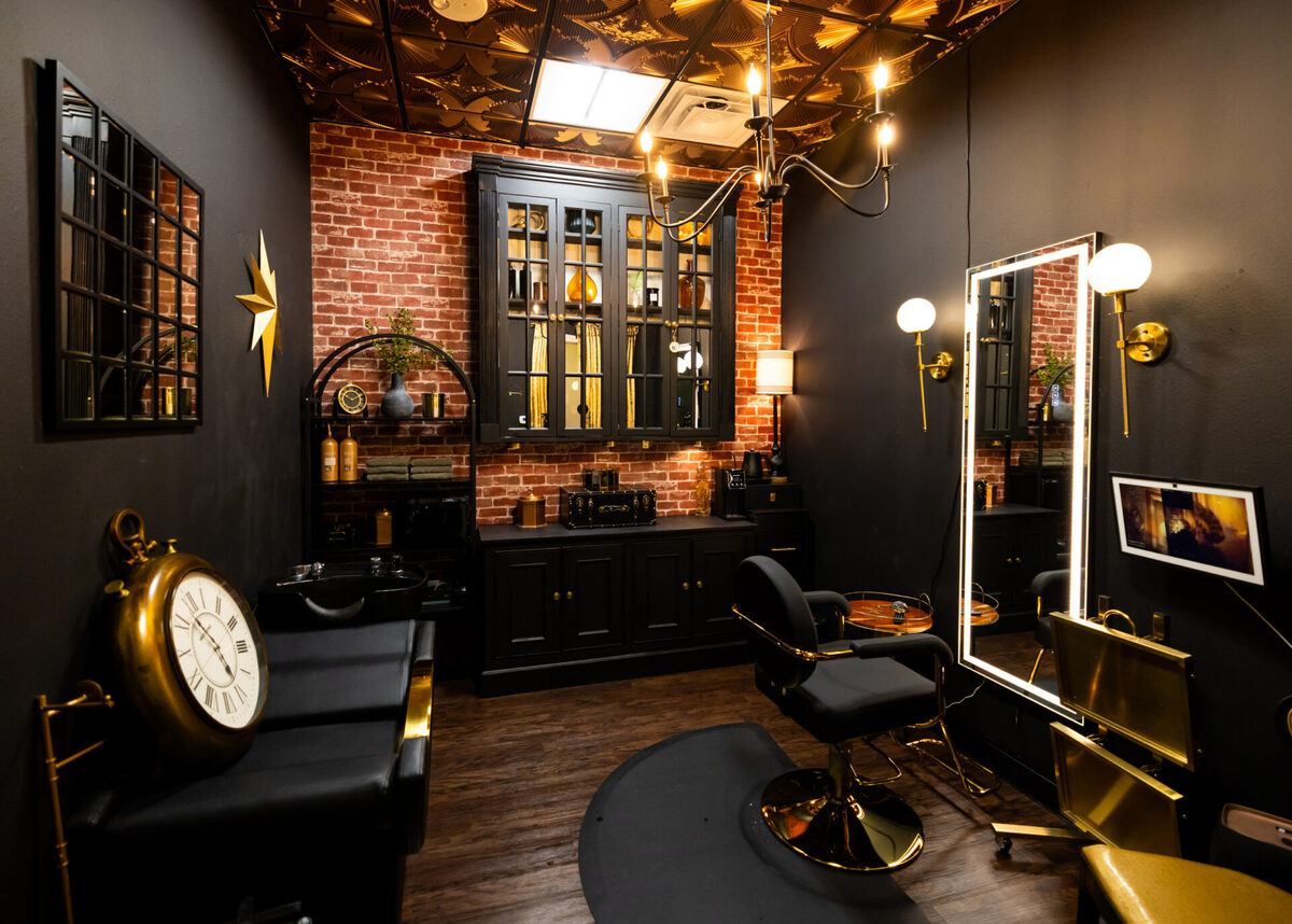 Black and gold barber suite with exposed brick wall