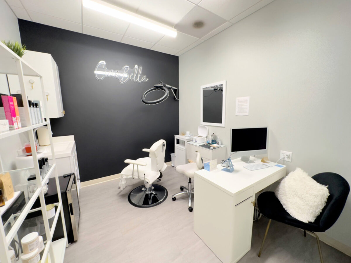 Esthetician suite with neon sign and treatment chair