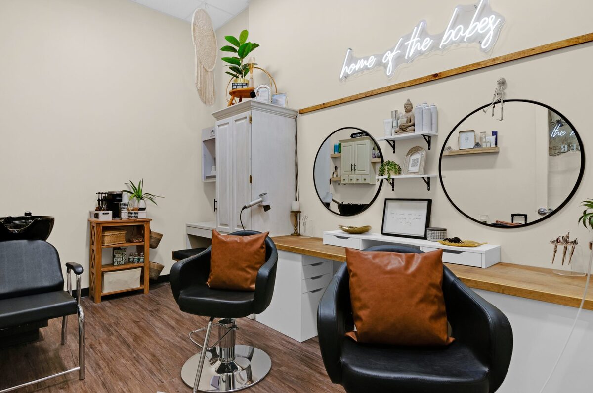 Boho hair salon with neon sign and round mirrors