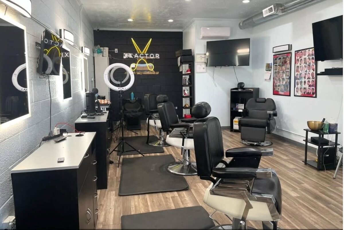 Barber shop with neon scissors sign and multiple styling chairs