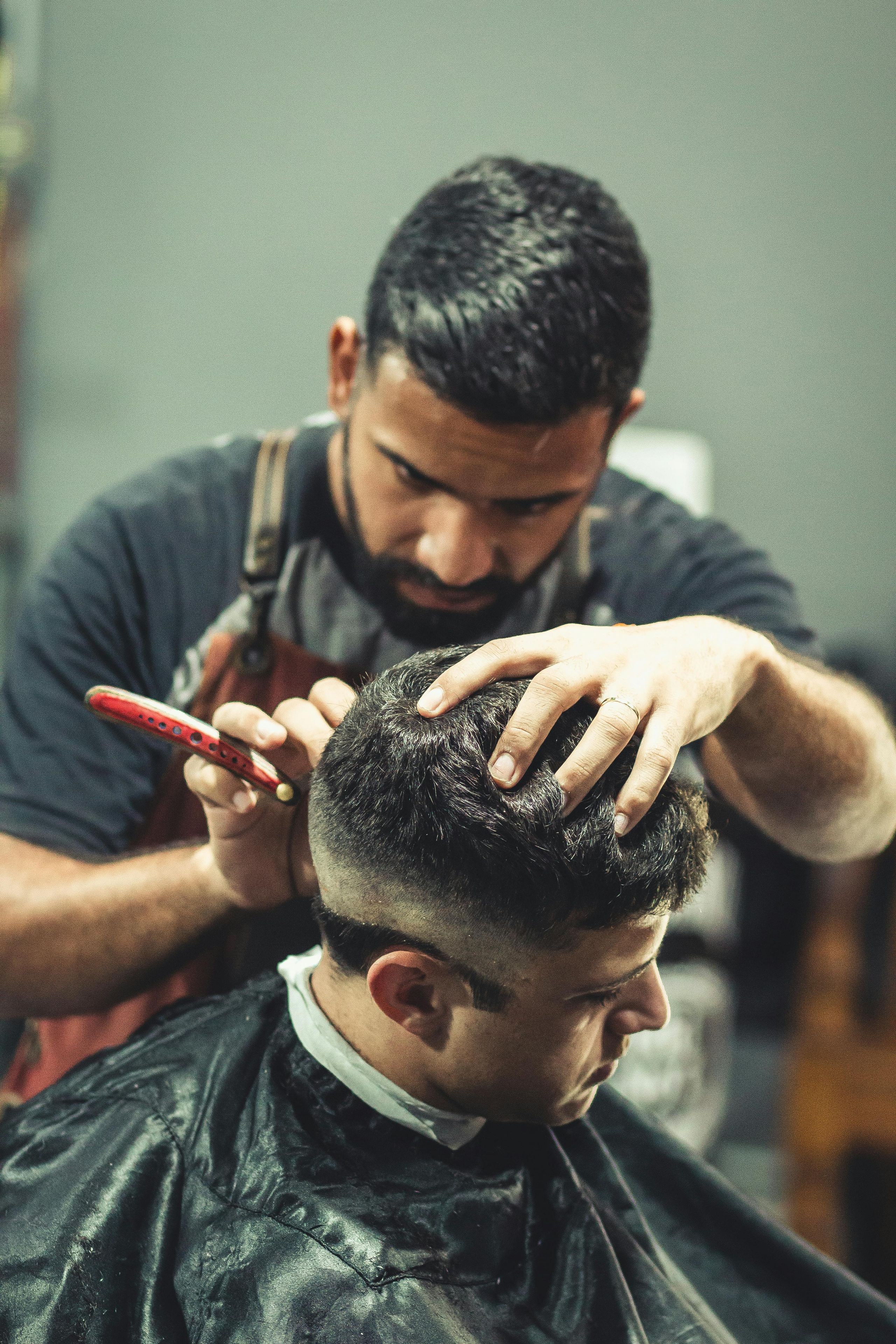 Barber cutting a client's hair with professional tools