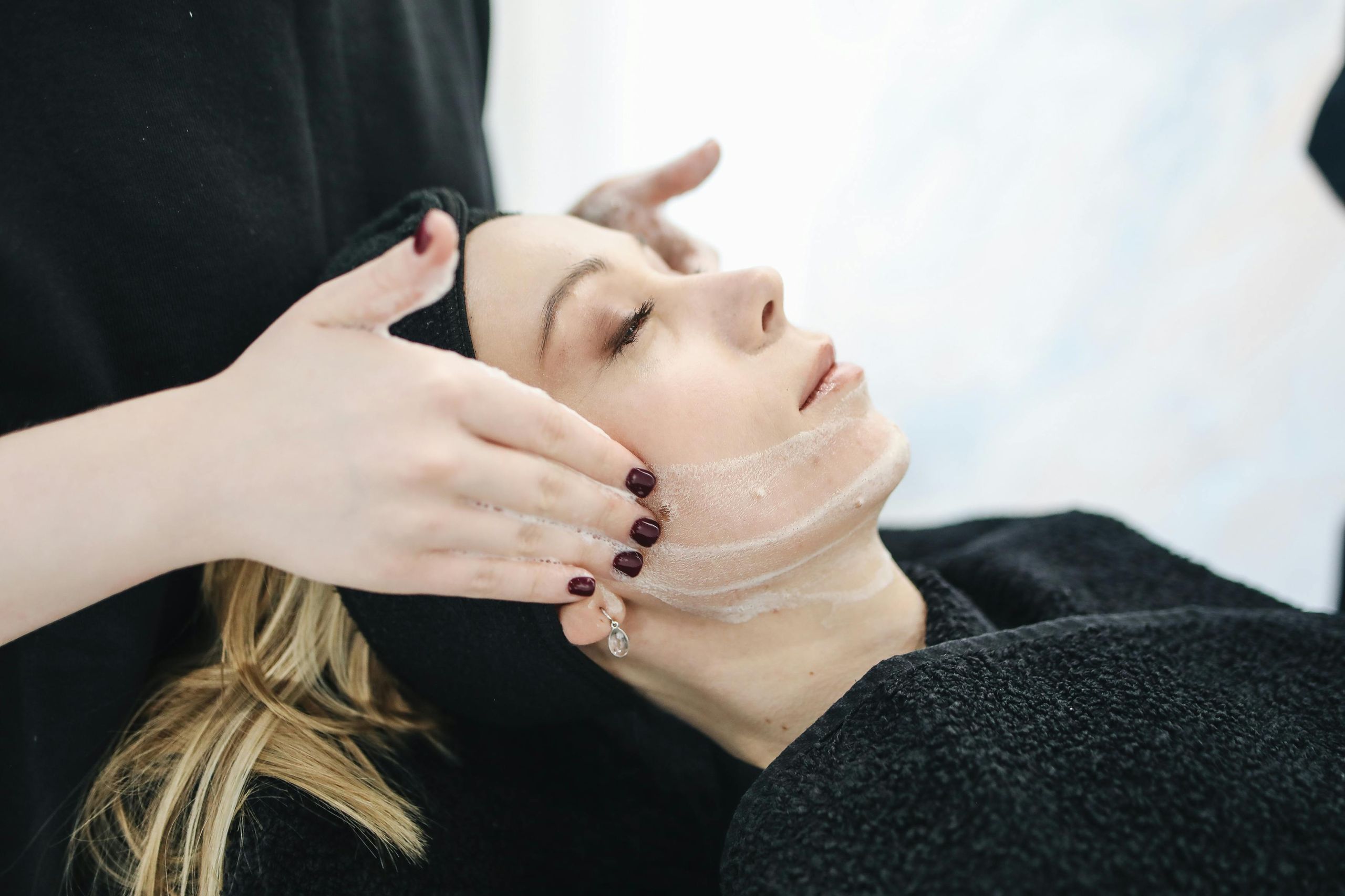 Esthetician providing a facial treatment in a spa room