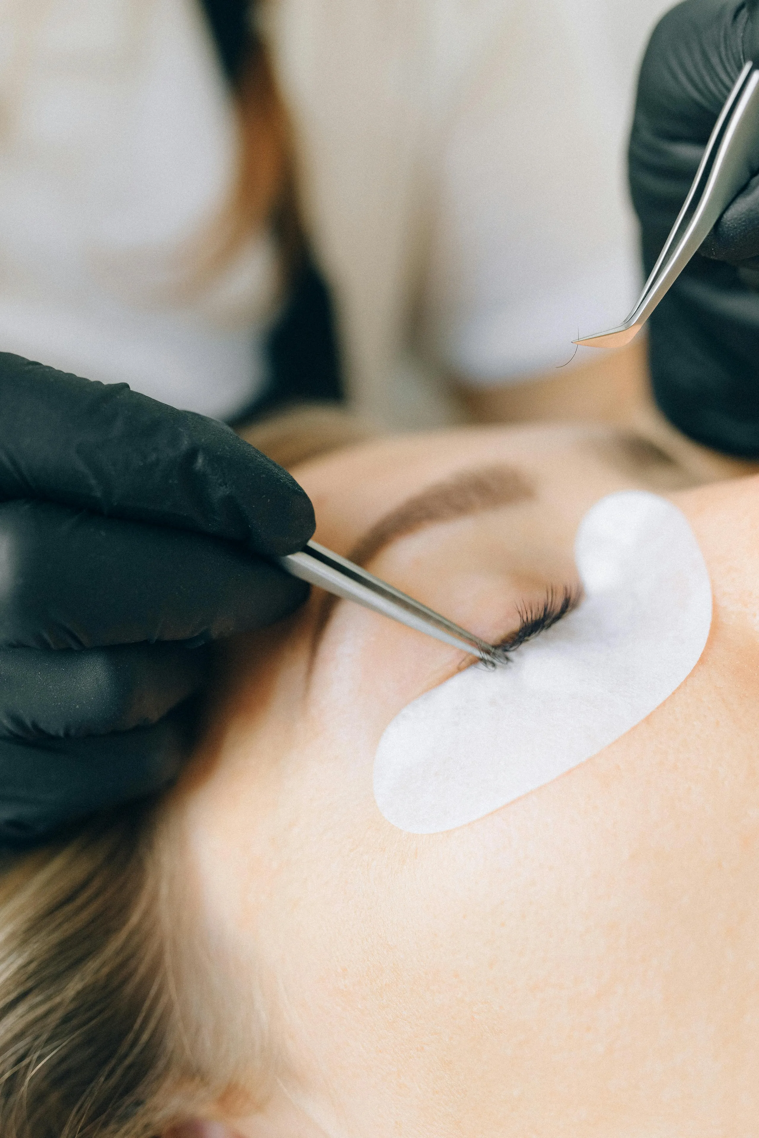 Lash professional applying eyelash extensions for a client
