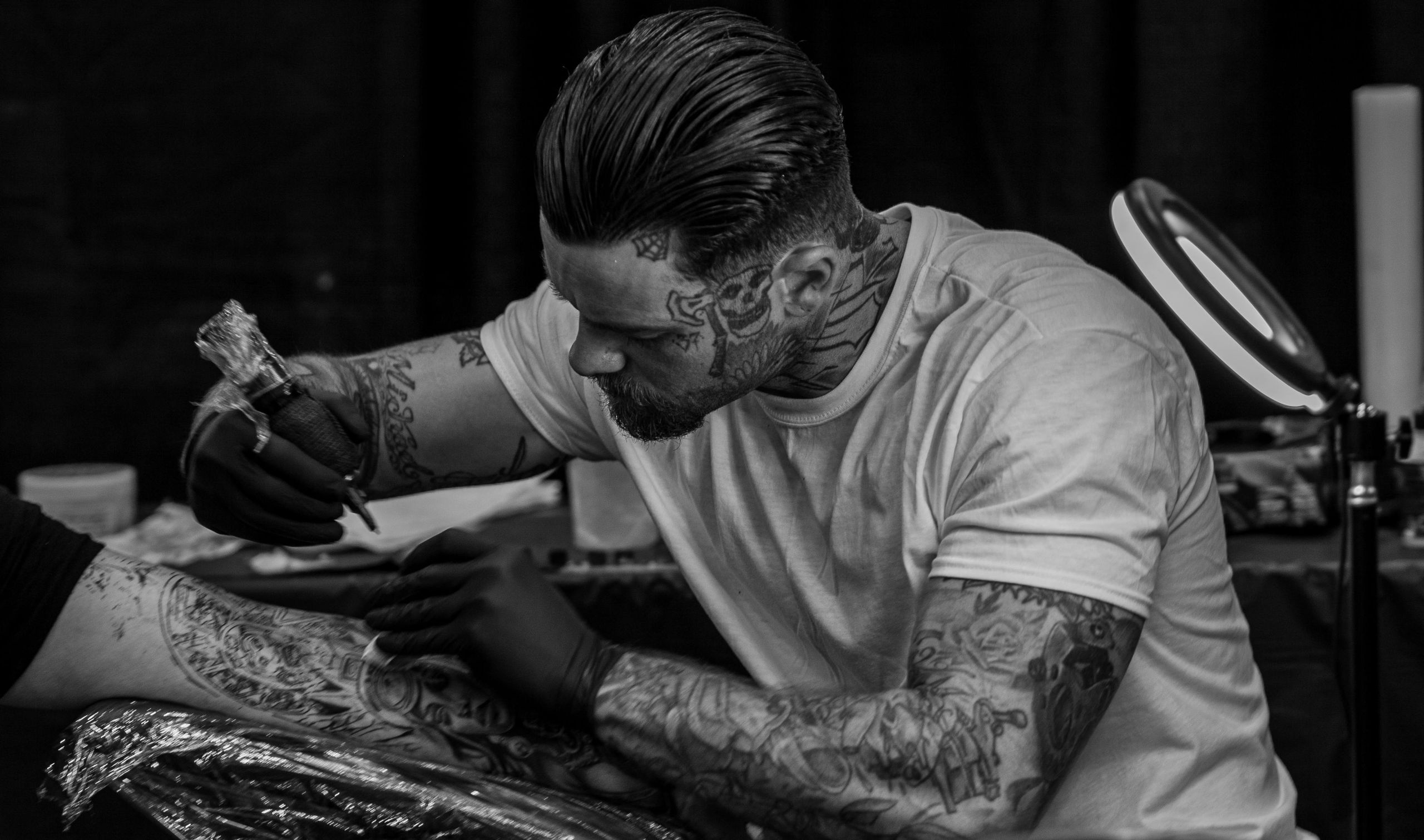 Tattoo artist working carefully with a client in a professional studio